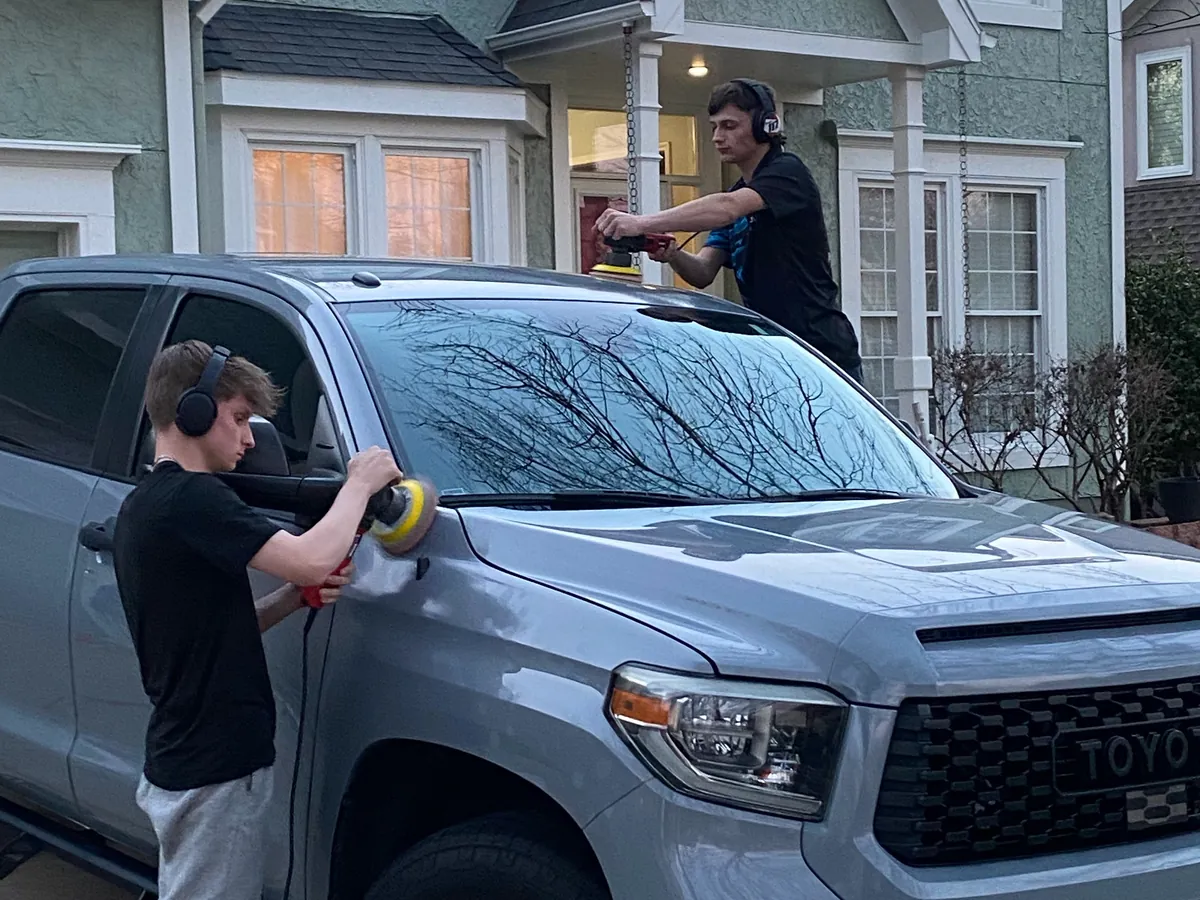 Aqulux techs detailing a Toyota Tundra in a customer's driveway